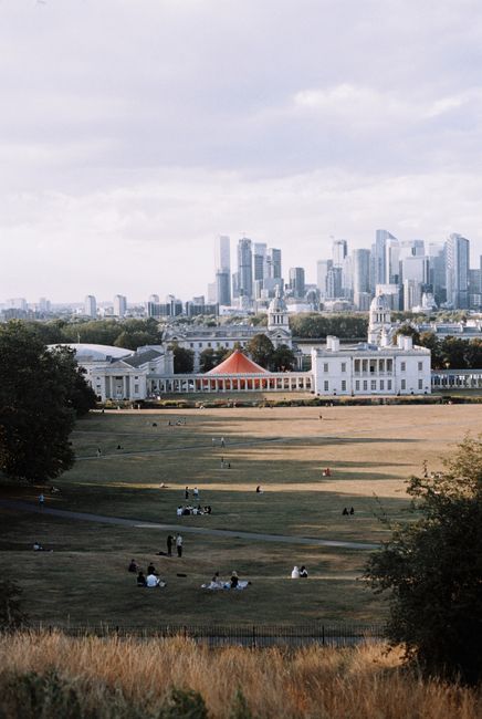 A photo of historical white stone buildings with domed roofs, columns, and detailed architectural elements, situated under a clear blue sky with some wispy clouds. The buildings are part of a historic
